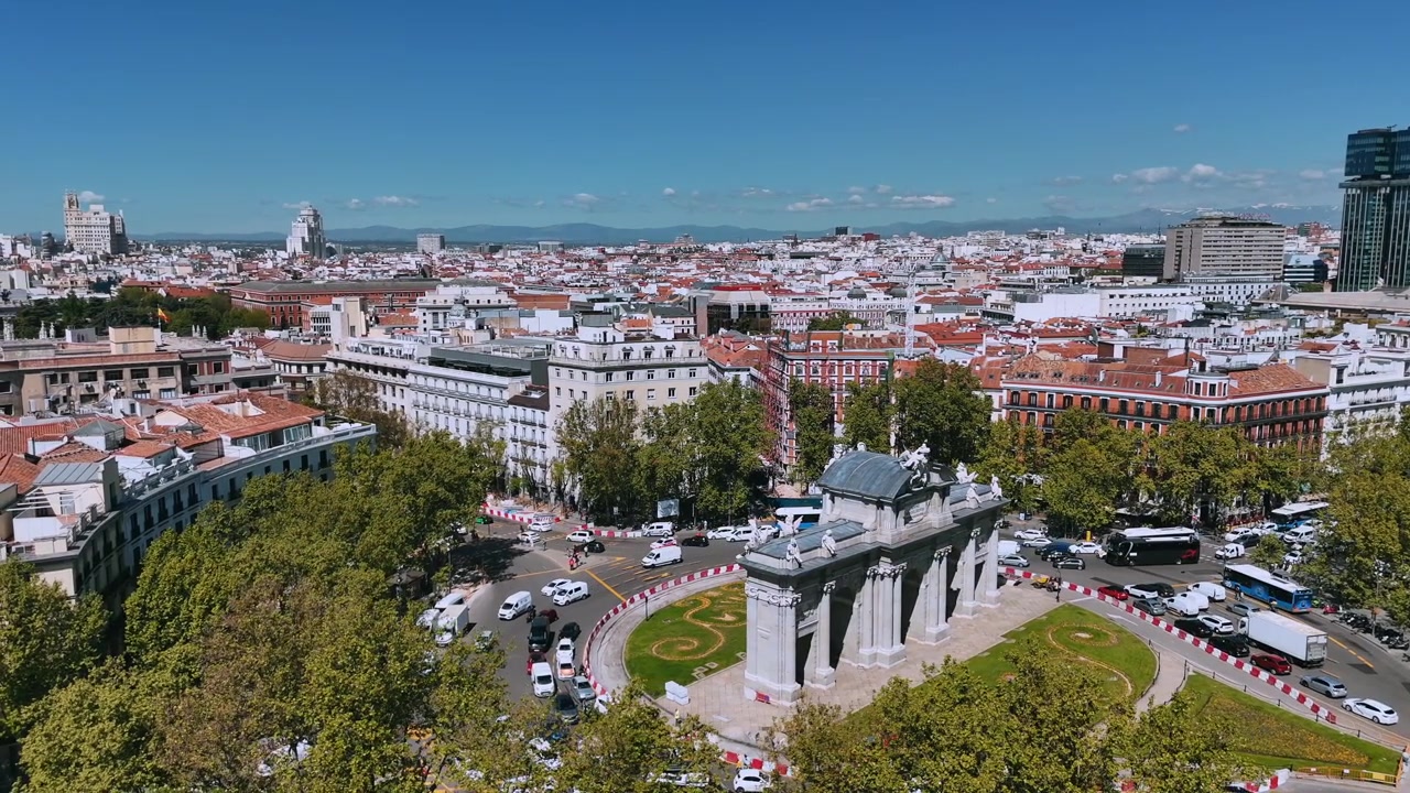 Vista drone della Puerta de Alcalá circondata dai tetti del centro di Madrid e dal traffico