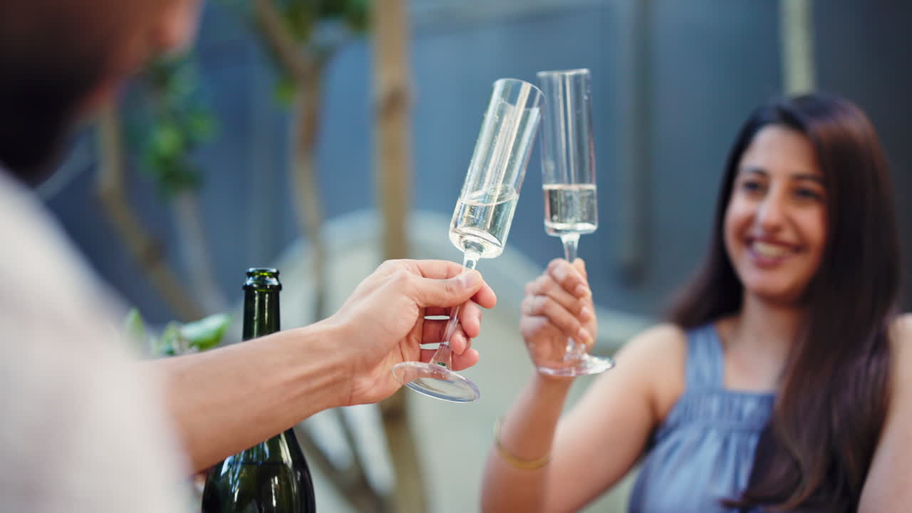 Lykkeligt par skåler med champagneglas udendørs