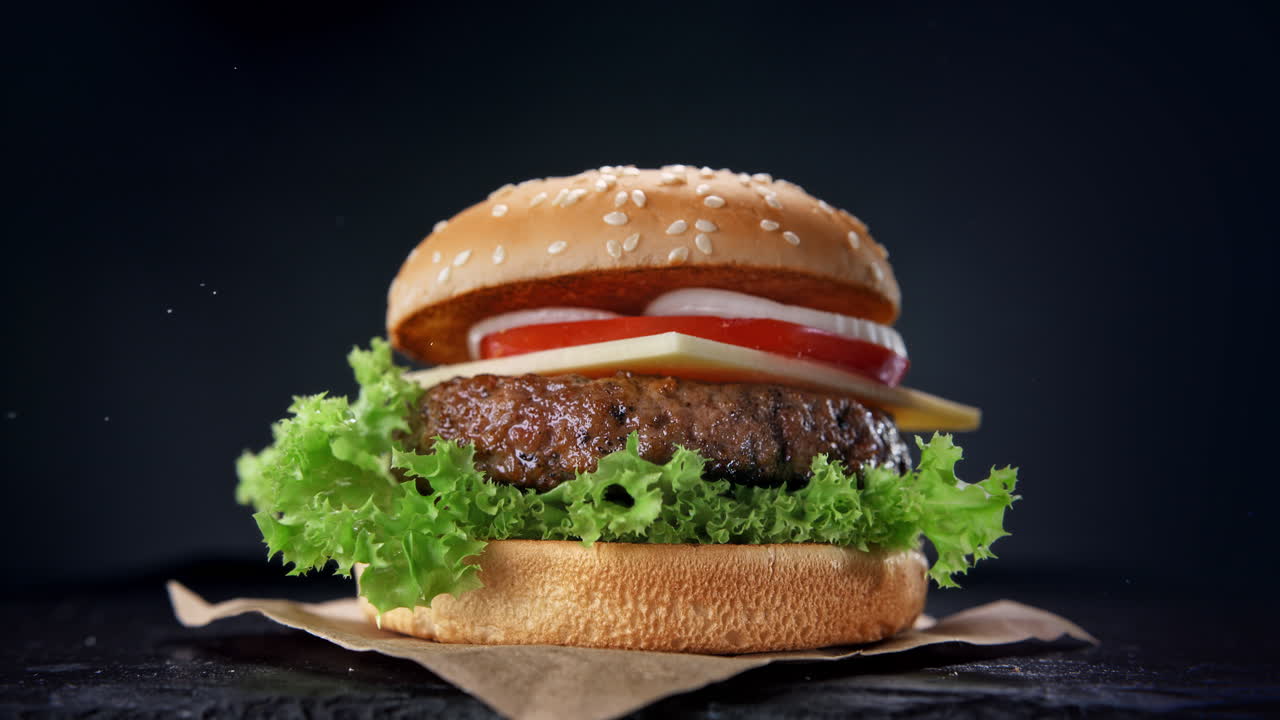 montar una hamburguesa - ingredientes de hamburguesa de carne cayendo y aterrizando en el pan uno por uno en cámara lenta