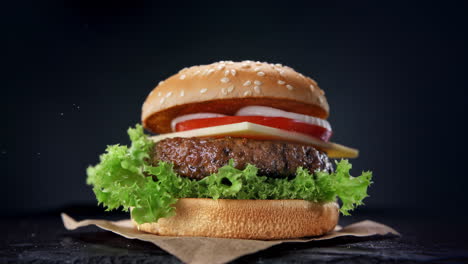 assembling a burger - beef burger ingredients falling and landing in the bun one by one in slow motion