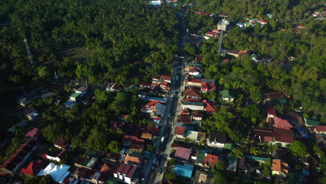 Aerial-view-of-a-landscape-with-colorful-homes,-a-road-and-mountains-in-Luzon,-Philippines