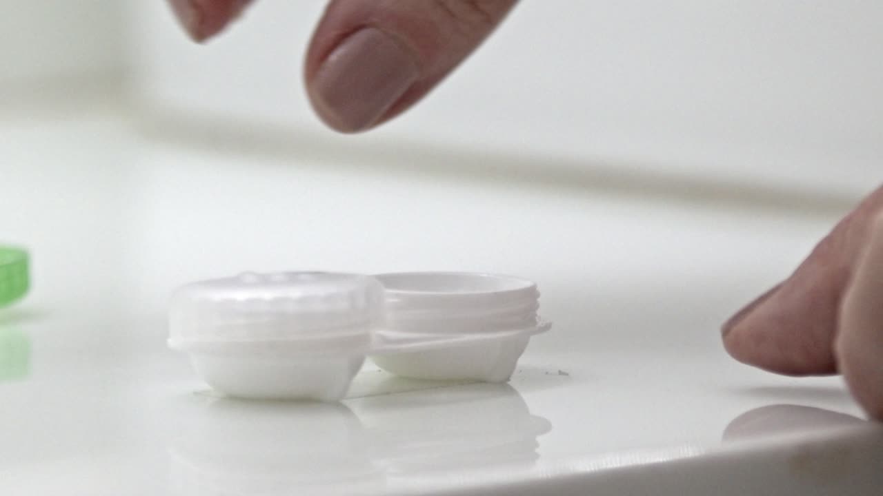 Slow careful preparation, disposable flimsy contact lens capsules, slow-mo
