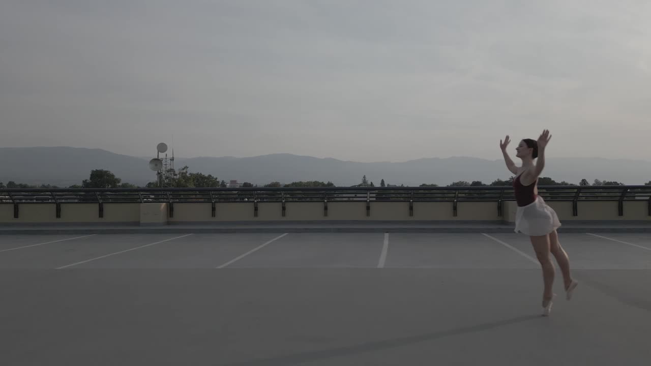 persecución lateral de una bailarina de ballet en un techo parkade