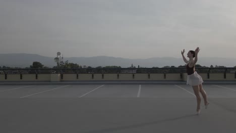 Side-chase-of-a-ballet-dancer-on-a-parkade-roof