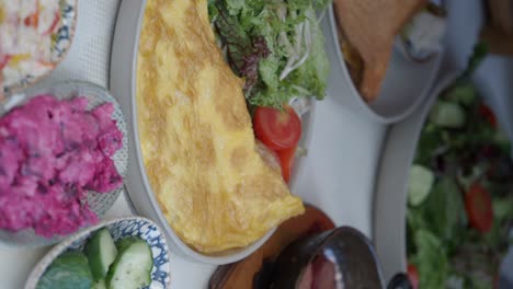 breakfast plate with omelette, salad, and sides