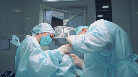 dentist man and his assistant woman treat patient's teeth on the background of medical center. oral treatment in clinic by orthodontist and a nurse. side view.