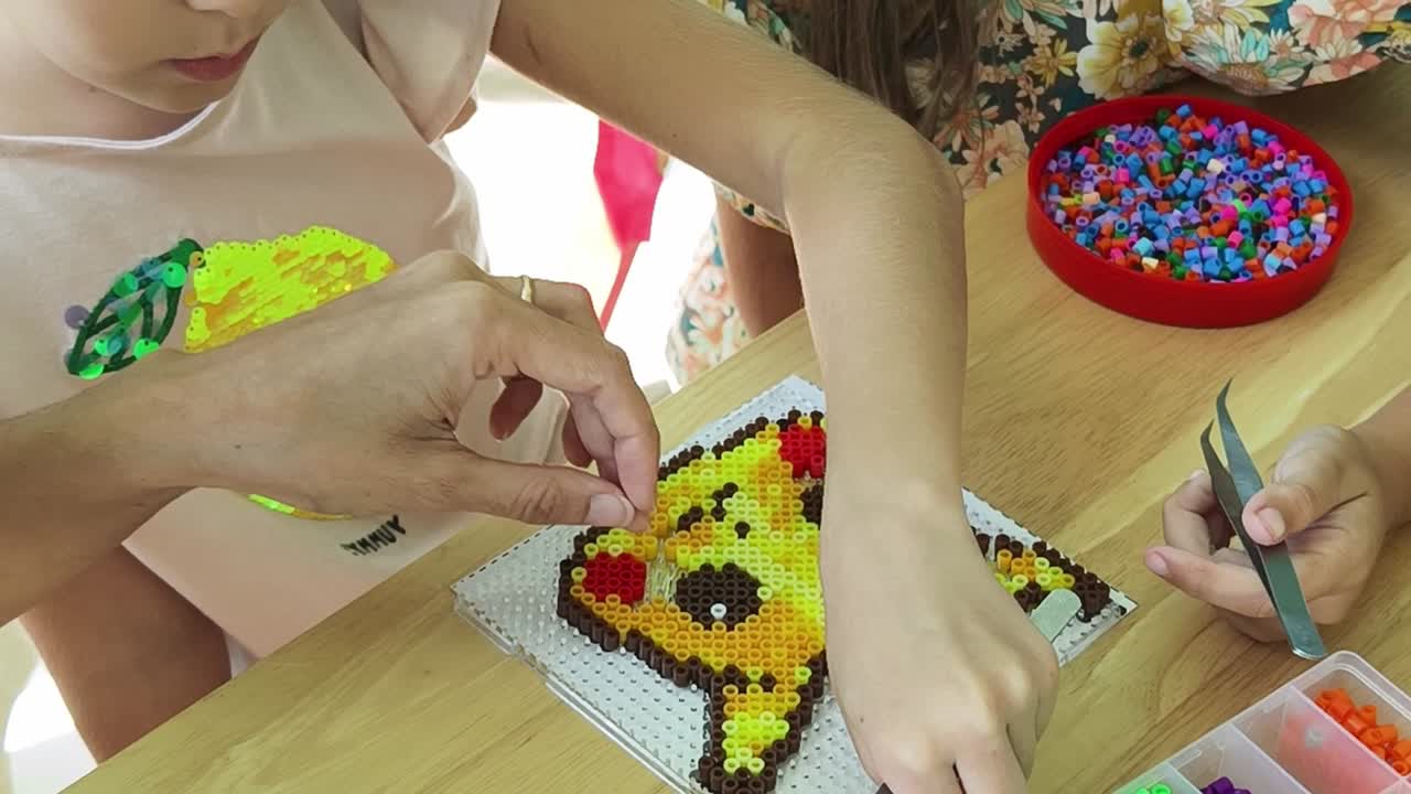 niños haciendo arte de cuentas de pikachu
