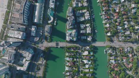 Top-down-shot-of-traffic-on-multilane-road-leading-on-bridges-over-water-and-passing-through-island.-Luxury-urban-borough-with-high-rise-buildings.-Miami,-USA