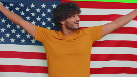 Young-indian-man-waving-and-wrapping-in-American-USA-flag,-celebrating,-human-rights-and-freedoms