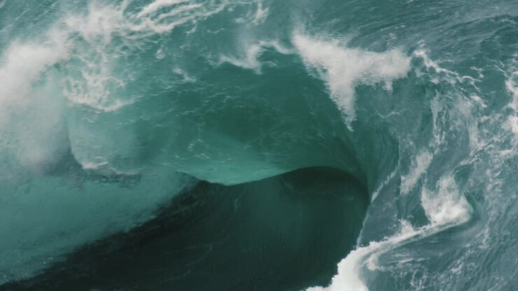 Thick lip of a wave breaking onto a shallow reef. Close up slow motion shot.