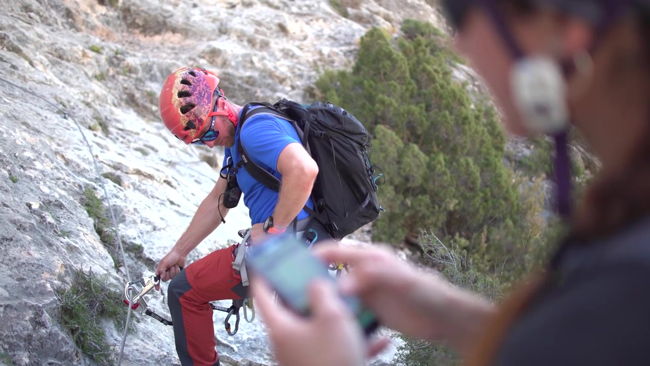 Via ferrata ascension by a couple sportsmen. View of mountain and mountaineers climbing in Alicante, Spain.
