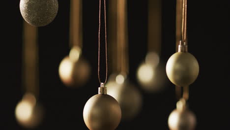 Video-of-gold-baubles-christmas-decorations-with-copy-space-on-black-background