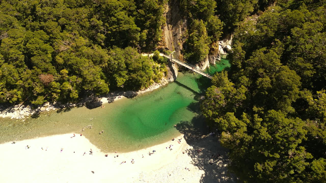 playa, río y pequeño puente rodeado de denso bosque, nueva zelanda, antena
