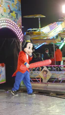 mickey mouse character entertains kids on a vibrant amusement park train ride at night
