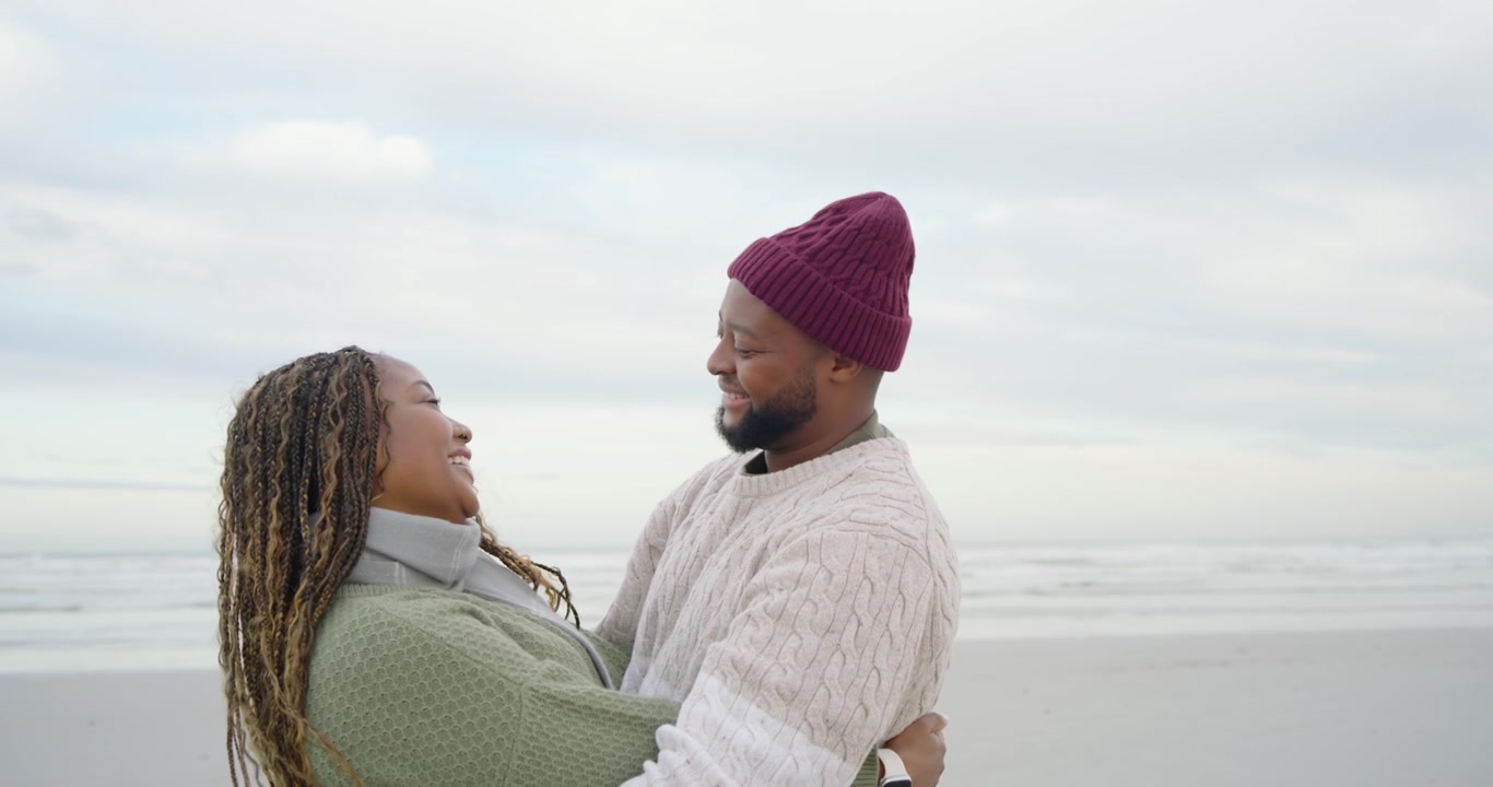 African American couple meeting on shore, taking hands, embracing tightly, showing love, man in cap