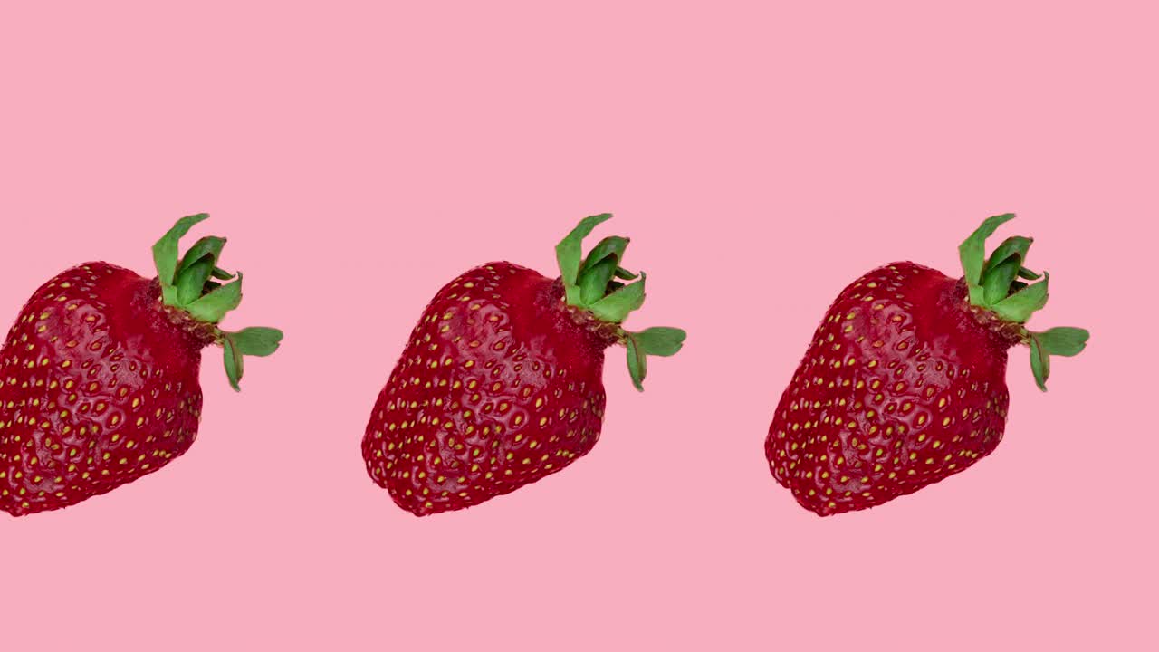 animación de bucle sin costuras con una fila de fresas rojas en un fondo rosa. hermosas bayas jugosas es un concepto de cosecha y verano. plantilla para publicidad con espacio de copia