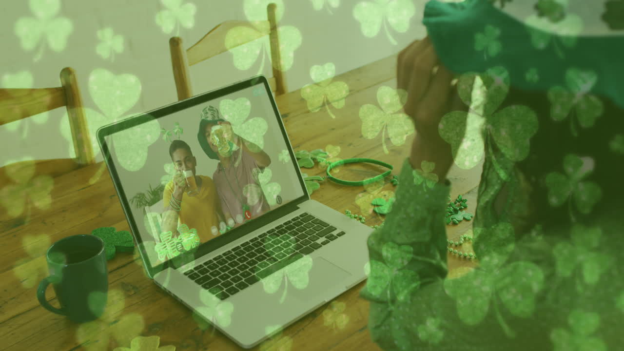 hojas de trébol cayendo contra la mujer que lleva gafas de trébol mientras tiene una videollamada en casa