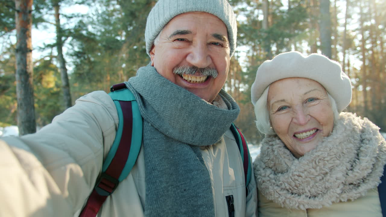 Happy Senior Couple Taking a Selfie in Winter Forest