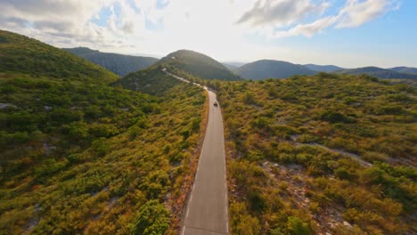 pintoresca vista aérea de drones siguiendo a un auto conduciendo a lo largo de una pintoresca carretera en las colinas de cataluña, españa