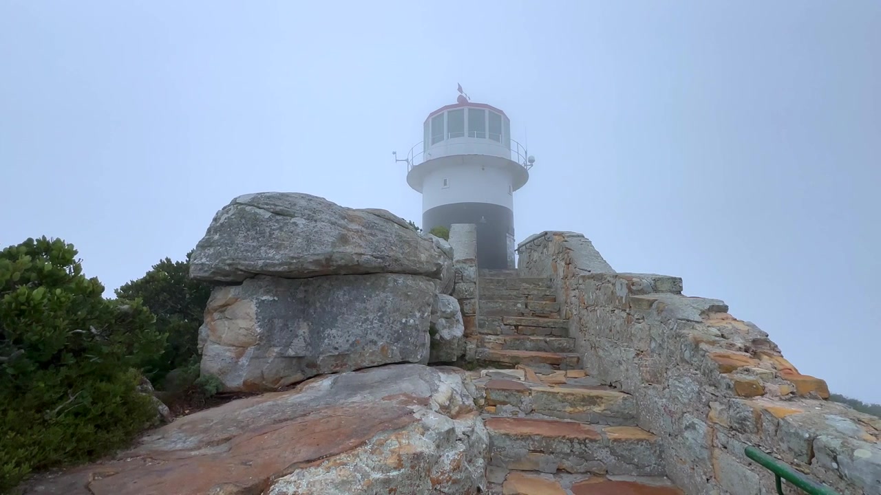 Cảnh quay lia phải ngọn hải đăng Old Cape Point trong sương mù buổi sáng. Nam Phi.