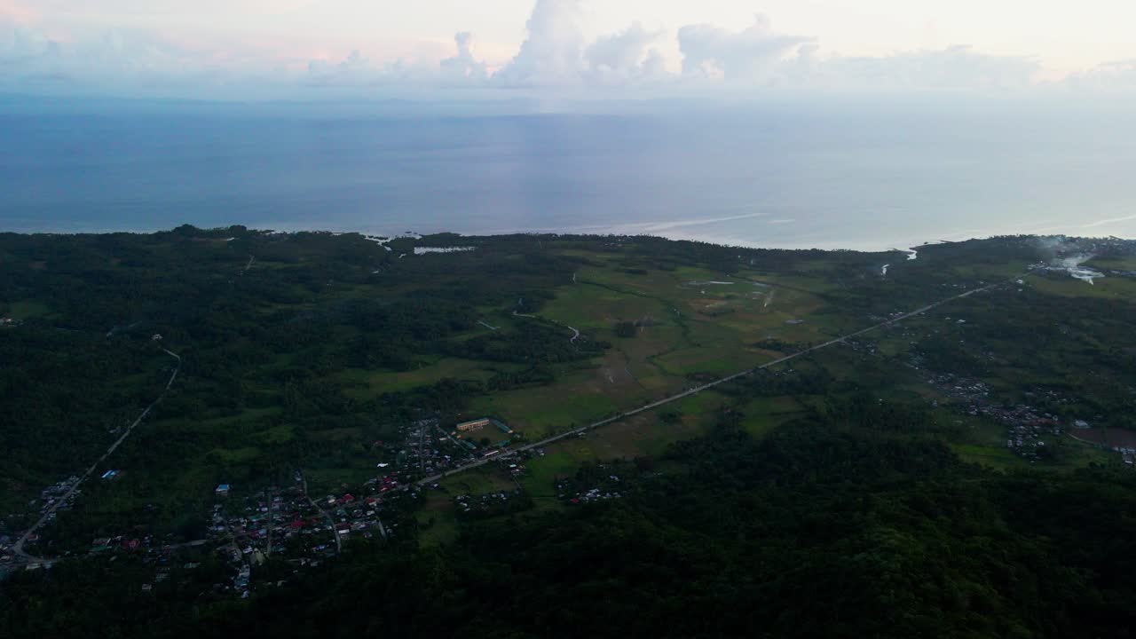 Panoramic aerial flyover of a tropical island province with lush hills, calm coast waters, and developing barangay towns - San Andres, Catanduanes, Philippines