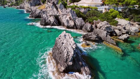 aerial view of rocky coast with turquoise waters and lush green hills