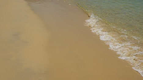 Sandy-Beach-Waves-Lapping-Shore-Close-Up,-Exotic-Idyllic-Picture-Perfect-Beaches-in-Zanzibar-in-Tanzania-in-Africa-with-Beautiful-Turquoise-Blue-Crystal-Clear-Sea-Water,-Background-with-Copy-Space