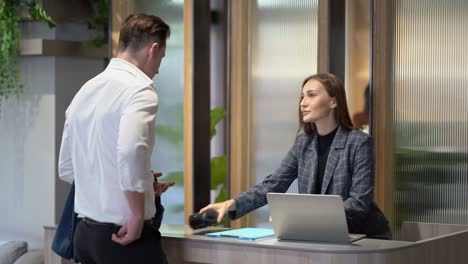 business man arrive to hotel check in ot check out pay by credit card  and ask for information to receptionist woman registration at reception counter