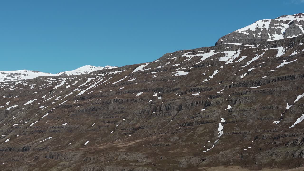 gufufoss에 가까운 아이슬란드의 높은 곳에 위치한 산 위로 패닝 및 틸팅