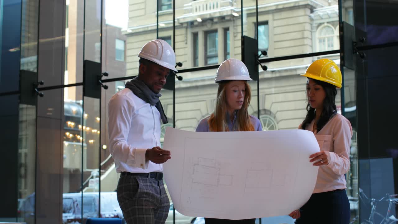 Group of architects discussing over blueprint in office 4k