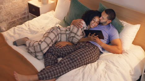 Couple,-happy-and-hug-in-bedroom-with-tablet