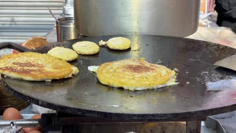 algunos newari bara fritos en una sartén en un mercado local en nepal