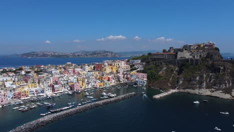 aerial view of marina corricella port on procida islands off the coast of naples, waterfront colourful housing and church, italy