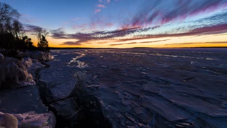 Dramatischer-Sonnenuntergang-Im-Zeitraffer-An-Einem-Zugefrorenen,-Eisigen-See-Im-Winter