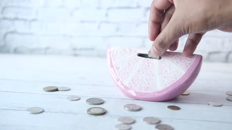 pink ceramic orange slice piggy bank with coins