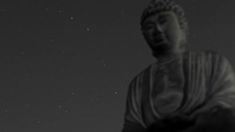 un cielo estrellado pasa sobre un buda de piedra en un lapso de tiempo