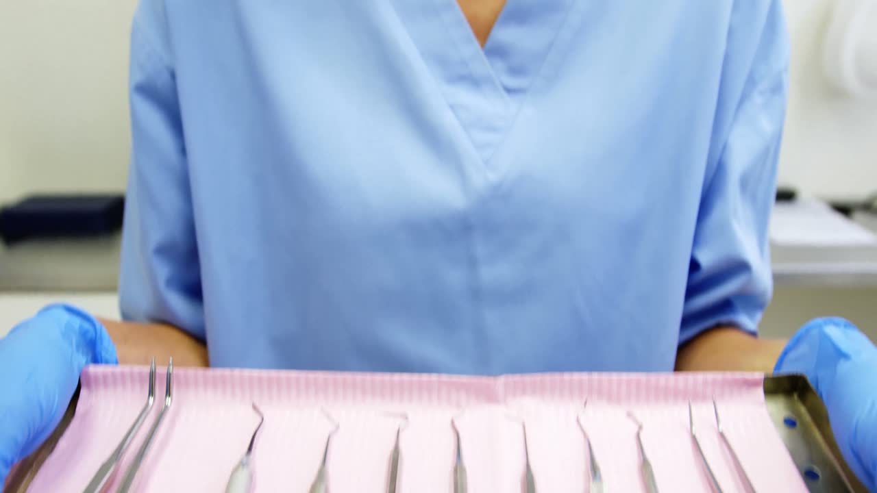 asistente dental que sostiene la bandeja con el equipo