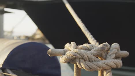 close up detail of a knot in a rope securing a boat tied to a jetty