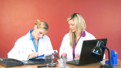 Female-doctors-signing-documents-in-office