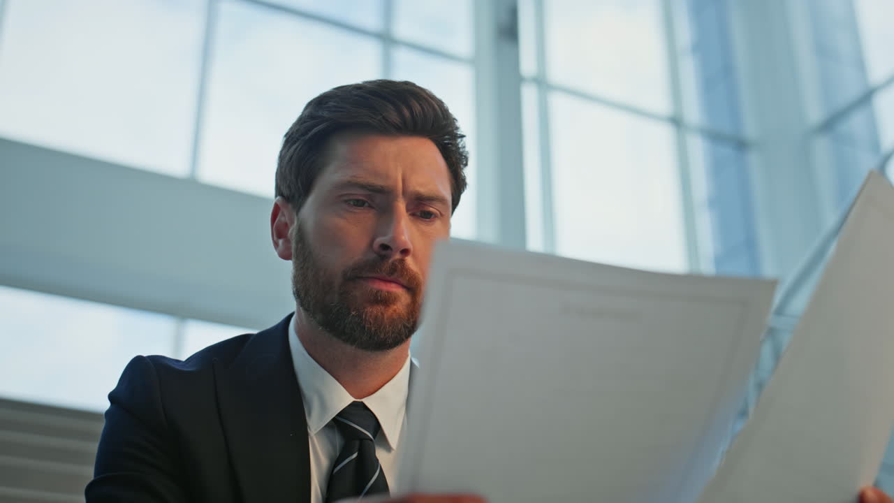 Serious ceo analyzing document dissatisfied information at office stairs closeup