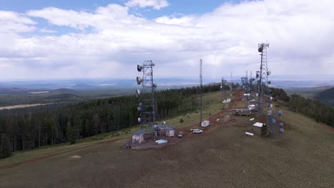 radio towers and lookout at the mountain peak in greens peak, arizona against the sky - aerial drone