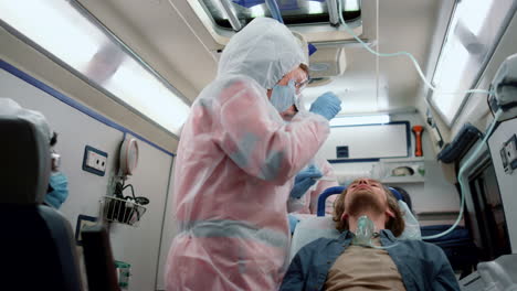 mixed race paramedics taking nasal swab of patient for coronavirus test