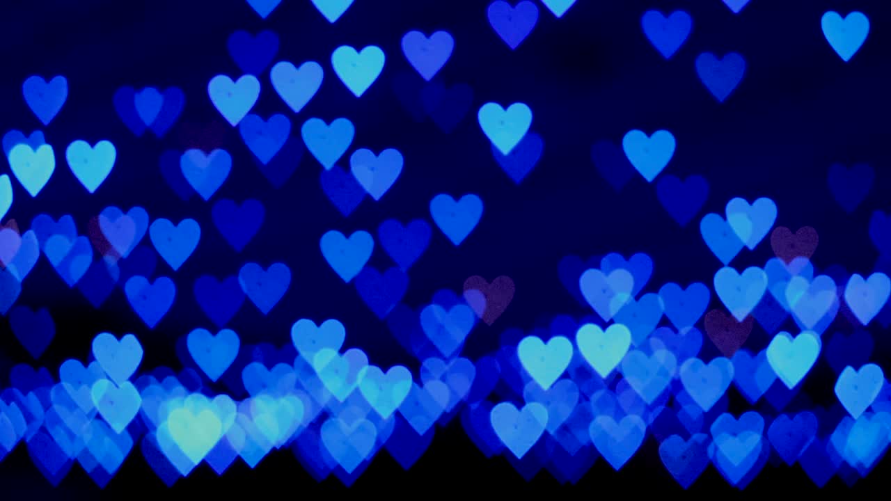 4k uhd video de fondo para el día de san valentín. frontera con bokeh de corazones azules brillantes románticos en un fondo oscuro. amor, bokeh en forma de corazón