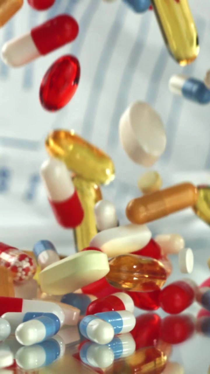 Colorful Pills and Capsules Falling in Slow Motion