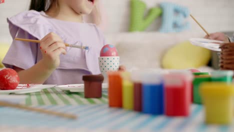 happy girl painting easter eggs