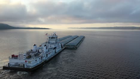 tugboat and barge on river at sunrise