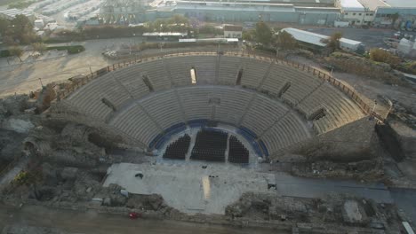 Aerial-view-of-The-Roman-Amphitheater-of-Caesarea-and-the-ancient-remains-of-the-coastal-city-of-Caesarea,-built-under-Herod-the-Great-during-22–10-BC