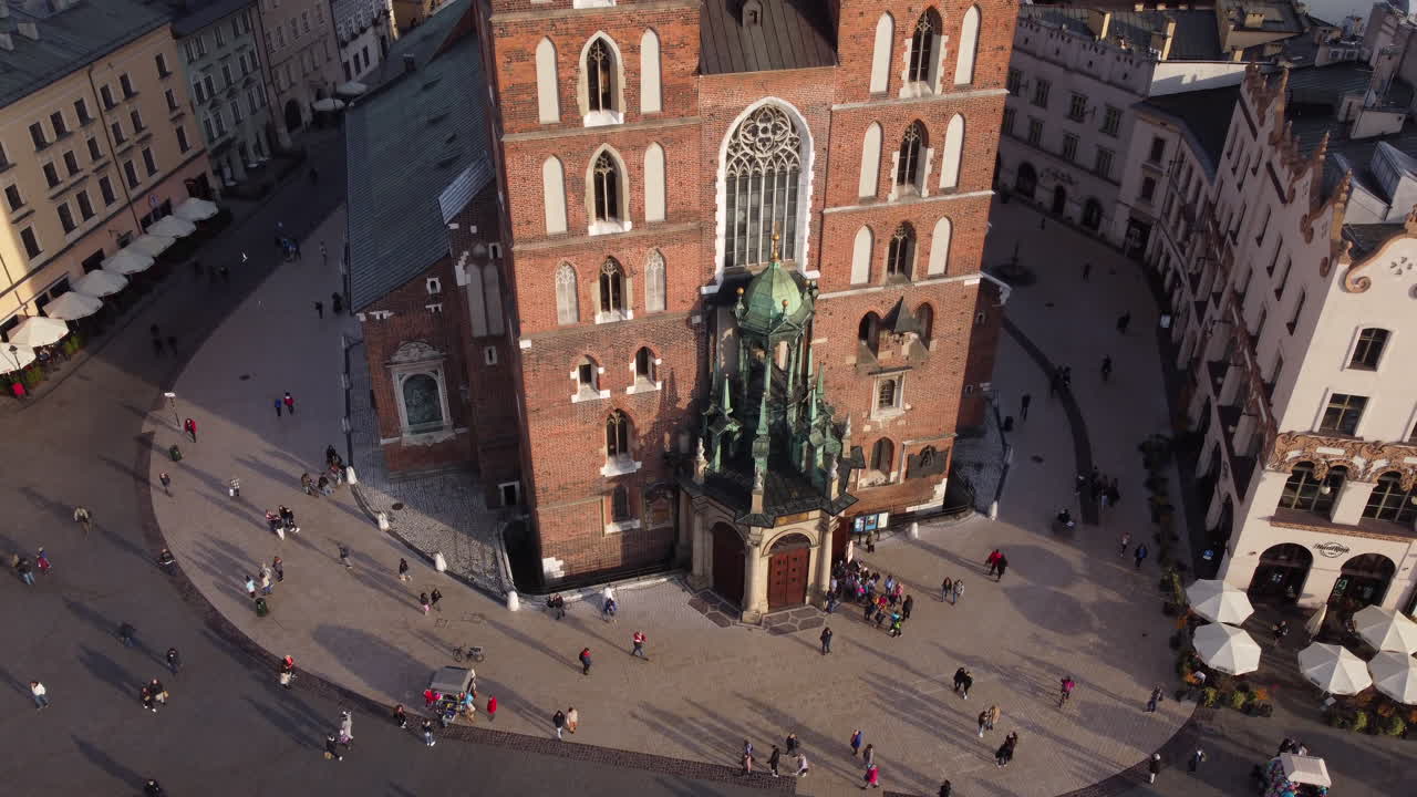 Flyfoto av folk som går foran Mariakirken i Krakow, Polen