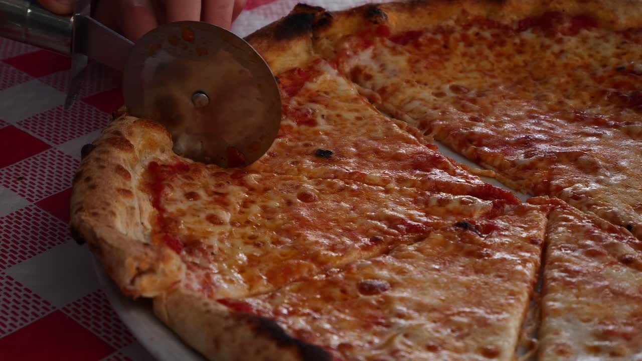 Bambino che fatica a tagliare una fetta di pizza. Slow motion x0,5
