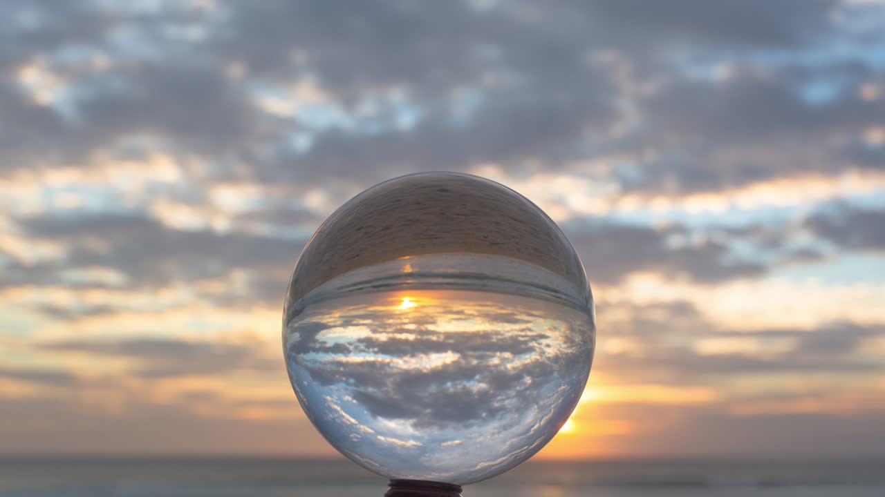 vista mágica del atardecer en la playa en una bola de cristal.